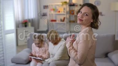 年轻的母亲欣赏女儿和祖母一起玩平板电脑